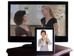 Imágen de mujer intérprete de lengua de señas en una tableta digital. Al fondo un televisor